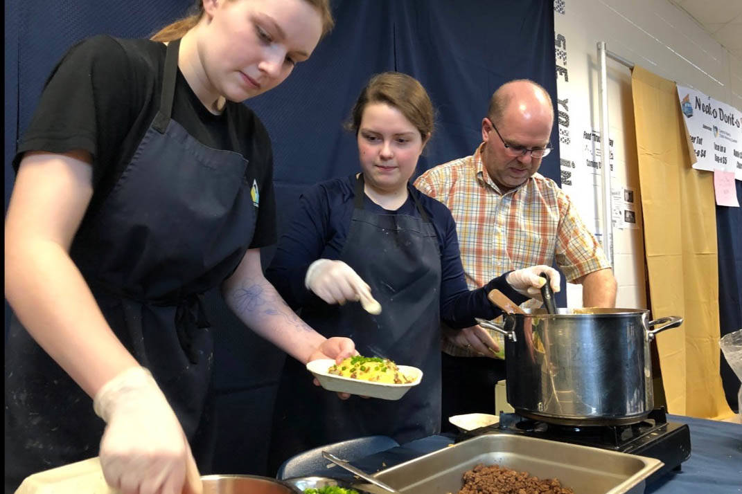 École Secondaire Notre Dame High School Grade 11 students Kaylee Wheaton, left, and Abby Ward serve up some Tex-Mex cuisine while James Ward helps with the cooking. All the money raised from Food Truck Friday goes toward the Central Alberta Child Advocacy Centre. Robin Grant/Red Deer Express