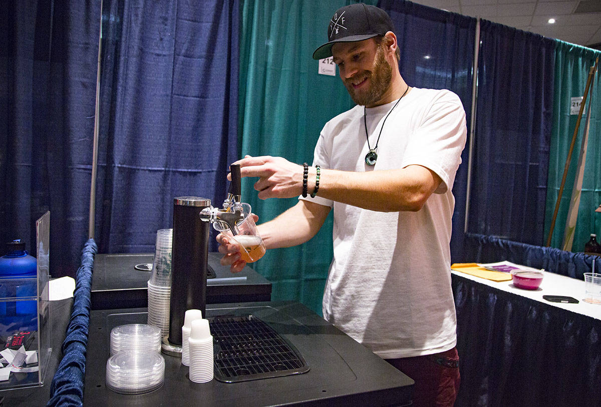 Sky Morgan pours a glass of kombucha at the Wild Brewing Co. booth at the Healthy Living Expo on Saturday at Westerner Park. He said kombucha is rich in probiotics, B vitamins and enzymes which can help your body’s digestive system. Robin Grant/Red Deer Express