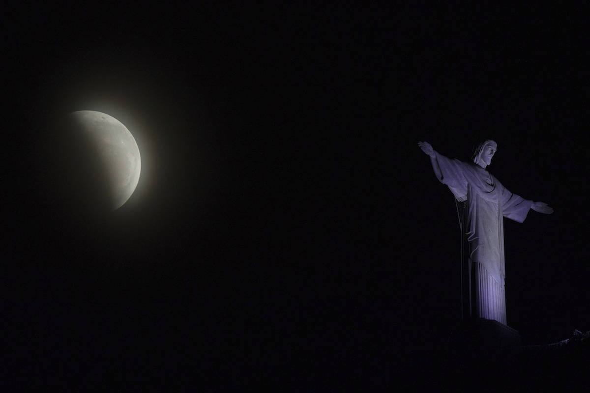 A blood moon rises above Christ the Redeemer statue during a lunar eclipse in Rio de Janeiro, Brazil, Monday, Jan. 21, 2019. (AP Photo/Leo Correa)