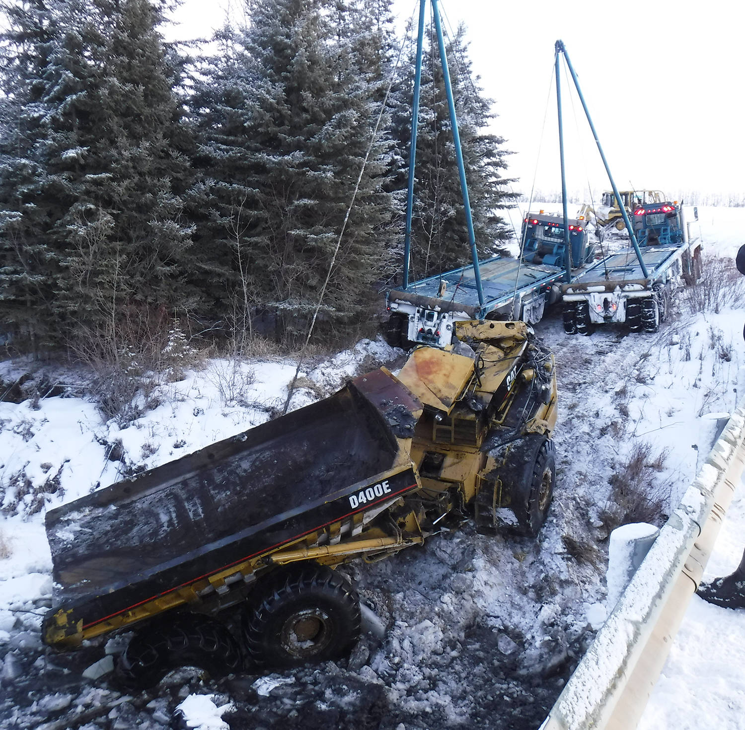 Emergency crews and two flat deck trucks from Calnash Trucking were used Friday morning to pull this large rock hauler out of the river. Alberta Environment was notified of the incident and that there was diesel that entered the river. Photo submitted