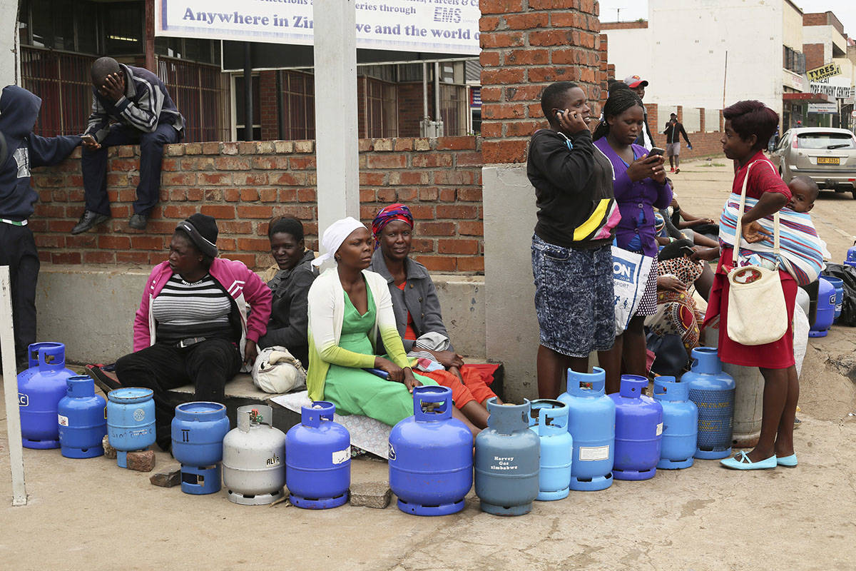 People wait in a queue for cooking gas at a garage in the capital Harare, Wednesday, Jan, 23, 2019. The Southern African nation remained tense as President Emmerson Mnangagwa’s call for national dialogue is met with skepticism, and reports of abuses by security forces continued. (AP Photo/Tsvangirayi Mukwazhi)