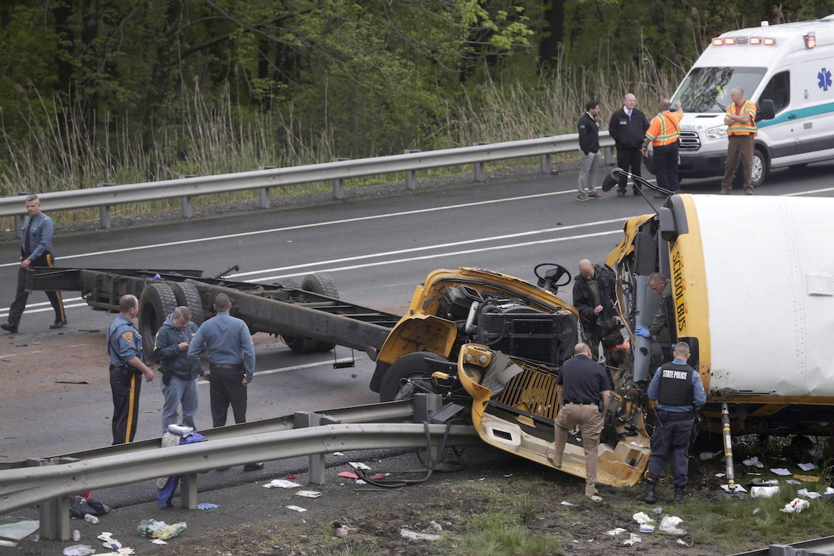 In a May 17, 2018 file photo, emergency personnel examine a school bus after it collided with a dump truck, injuring multiple people, on Interstate 80 in Mount Olive, N.J. (AP Photo/Seth Wenig, File)