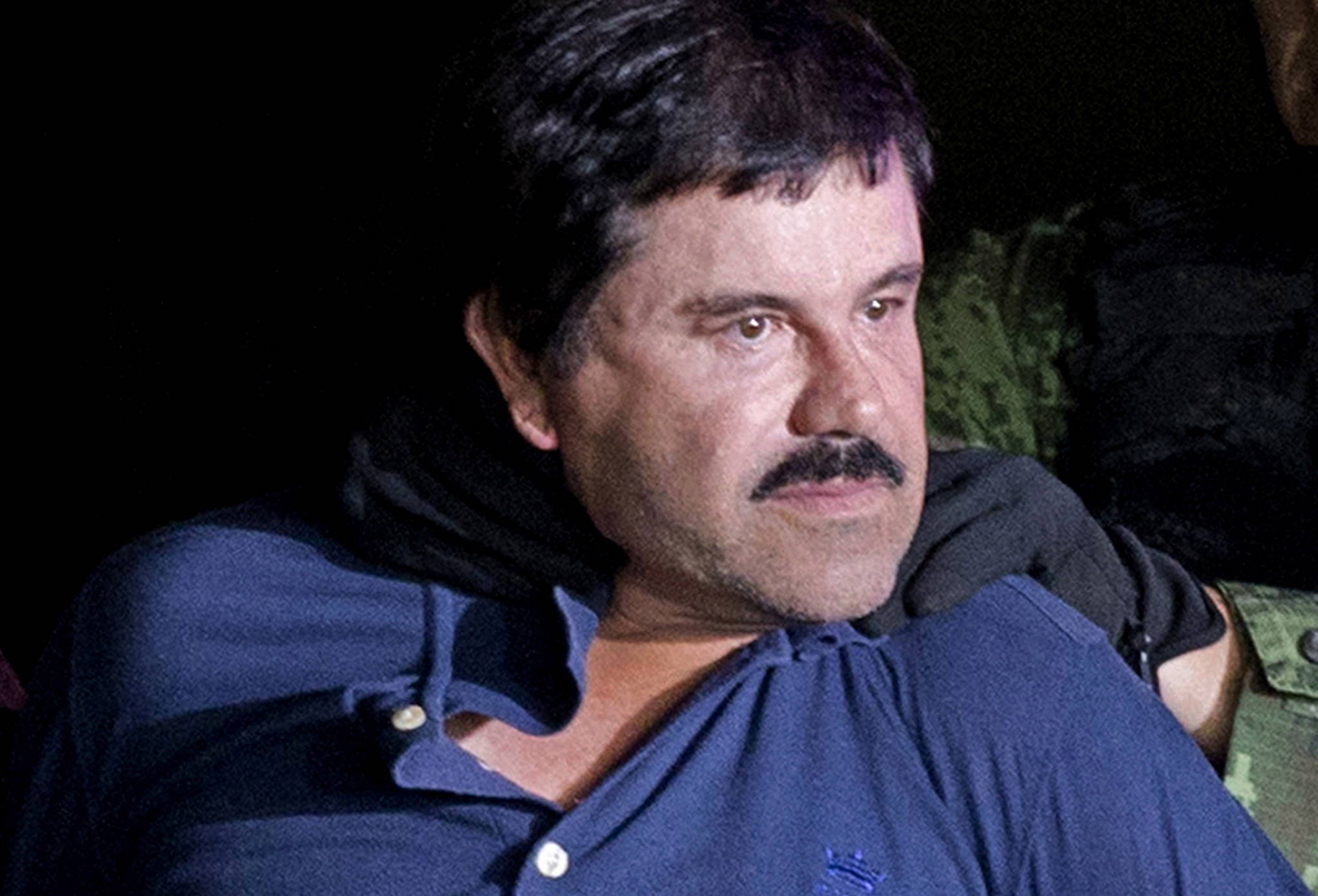 In this Jan. 8, 2016 file photo, drug lord Joaquin “El Chapo” Guzman is made to face the media in Mexico City as he is escorted by Mexican soldiers following his recapture six months after escaping from a maximum security prison. (AP Photo/Eduardo Verdugo, File)