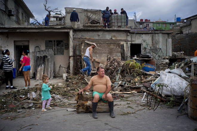 A man rests on the trunk of a tree that was toppled by a tornado, after removing rubble from his home in Regla, Cuba, on Monday, Jan. 28, 2019. AP Photo/Ramon Espinosa)