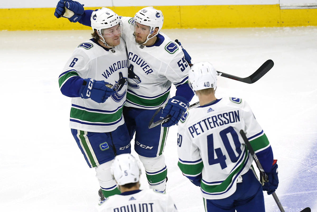 Vancouver Canucks defenseman Alex Biega (55) celebrates with right wing Brock Boeser (6) after his goal against the Chicago Blackhawks during the second period of an NHL hockey game Thursday, Feb. 7, 2019, in Chicago. (AP Photo Nuccio DiNuzzo)