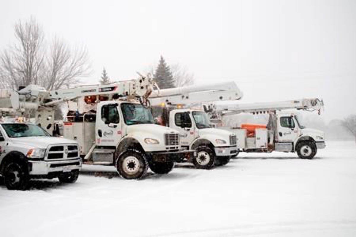 Trucks from the Bowlin Group, an energy company from Kentucky, idle in the parking lot of Plymouth Heights Christian Reformed Church in Grand Rapids, Mich., on Friday, Feb. 8, 2019. The church served as a staging area for the vehicles. (Neil Blake/The Grand Rapids Press via AP)