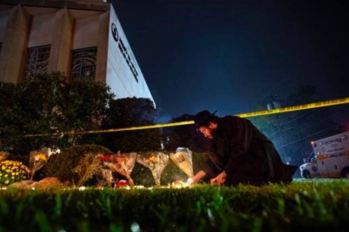 FILE - In this Oct. 27, 2018 photo, Rabbi Eli Wilansky lights a candle after a mass shooting at Tree of Life Synagogue in Pittsburgh’s Squirrel Hill neighborhood. Robert Bowers, a truck driver accused of killing 11 and wounding seven during an attack on the Pittsburgh synagogue in October is expected to appear Monday, Feb. 11, 2019, morning in a federal courtroom to be arraigned on additional charges. (Steph Chamber/Pittsburgh Post-Gazette via AP, File)