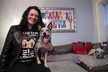 Lisa Topol poses with her two rescue dogs, Schmutzy, right, and Plop, in New York. (AP Photo/Mary Altaffer)