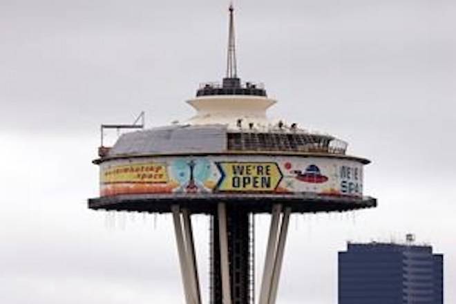 In this Feb. 7, 2018, file photo, workers climb atop the roof of the Space Needle, where most of the top is surrounded by a massive work platform, scaffolding and protective covering, as work on a major remodel of the iconic observation tower continues in Seattle.THE CANADIAN PRESS/AP/Elaine Thompson