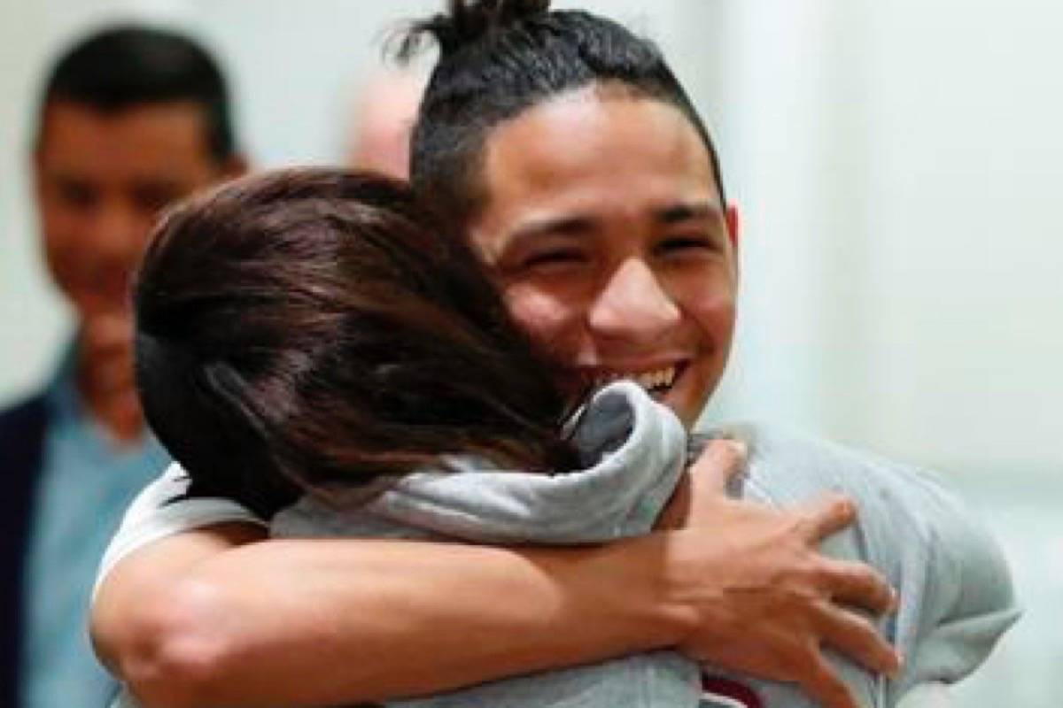 Anthony Borges, rear, who was shot during the Parkland, Fla., school shooting, hugs Marianne Sheehan after a news conference with Florida governor Ron DeSantis, Wednesday, Feb. 13, 2019, in Fort Lauderdale, Fla. DeSantis ordered a statewide grand jury investigation on school safety. (AP Photo/Wilfredo Lee)