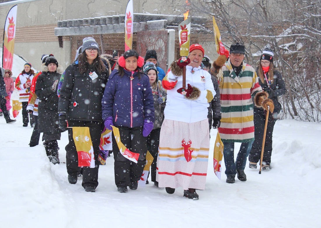 Theresa ‘Corky’ Larsen-Jonasson carries the torch from Fort Normandeau at the first torch run location in Red Deer to kick off the 2019 Canada Winter Games. Carlie Connolly/Red Deer Express