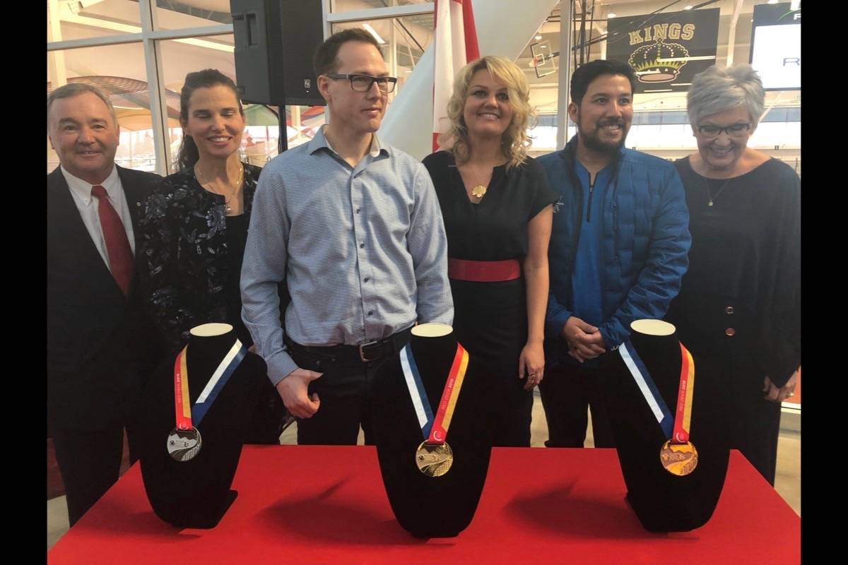 Canada Games Council Chairman Tom Quinn, Minister of Science and Sport Kirsty Duncan, Games medals designer Tyler Vreeling, Mayor Tara Veer, Tourism Minister Richardo Mirando and Games Host Society Chair Lyn Radford and others pose for a photo with the medals Friday. Robin Grant/Red Deer Express