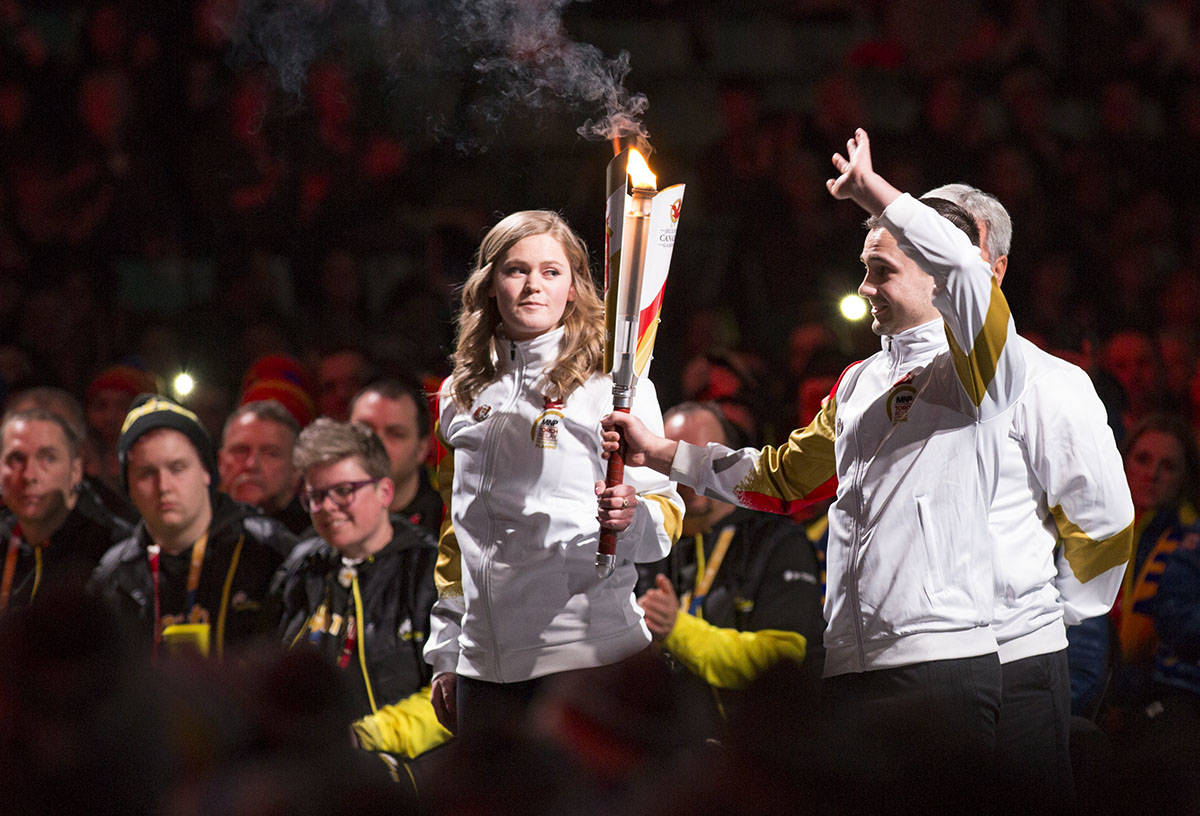 Alberta speed skater Maddison Pearman and Red Deer gymnast Mark Armstrong hold the torch before igniting the Canada Winter Games cauldron high above the audience. Robin Grant/Red Deer Express