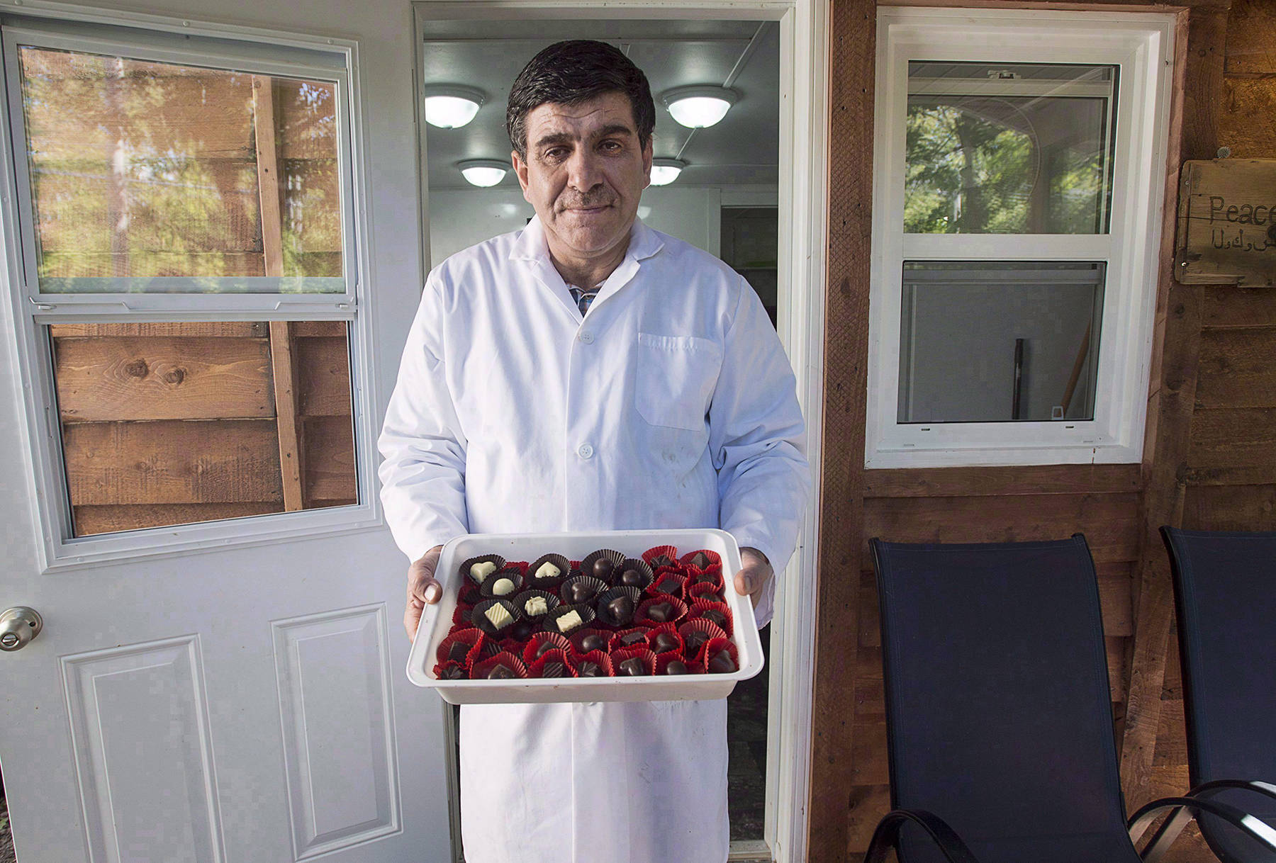 Assam Hadhad, a Syrian refugee who arrived in Canada last year, displays a tray of chocolates at his shop, Peace by Chocolate, in Antigonish, N.S. on Wednesday, Sept. 21, 2016. CEO Tareq Hadhad has plans to hiring more refugees over the next three years. (Andrew Vaughan/The Canadian Press)