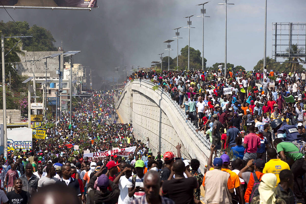 In this Feb. 7, 2019 photo, thousands of demonstrators march in the street as they chant anti-government slogans during a protest to demand the resignation of President Jovenel Moise and demanding to know how Petro Caribe funds have been used by the current and past administrations, in Port-au-Prince, Haiti. (AP Photo/Dieu Nalio Chery)