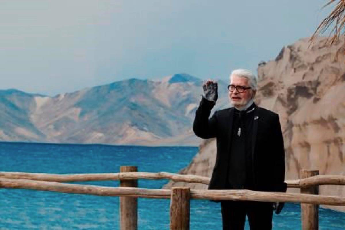 FILE - In this Tuesday, Oct.2, 2018 file photo, Karl Lagerfeld waves after the presentation of Chanel Spring/Summer 2019 ready-to-wear fashion collection in Paris. Chanel‚Äôs iconic couturier, Karl Lagerfeld, whose accomplished designs as well as trademark white ponytail, high starched collars and dark enigmatic glasses dominated high fashion for the last 50 years, has died. He was around 85 years old. (AP Photo/Christophe Ena, File )