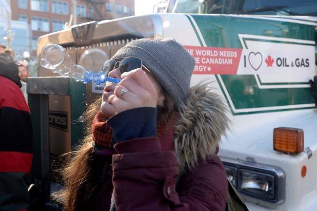 A protester blows bubbles as a convoy of angry Albertans and other westerners rolled up to Parliament Hill in Ottawa, Tuesday, Feb.19, 2019 to protest federal energy and environmental policies. (THE CANADIAN PRESS/Adrian Wyld)