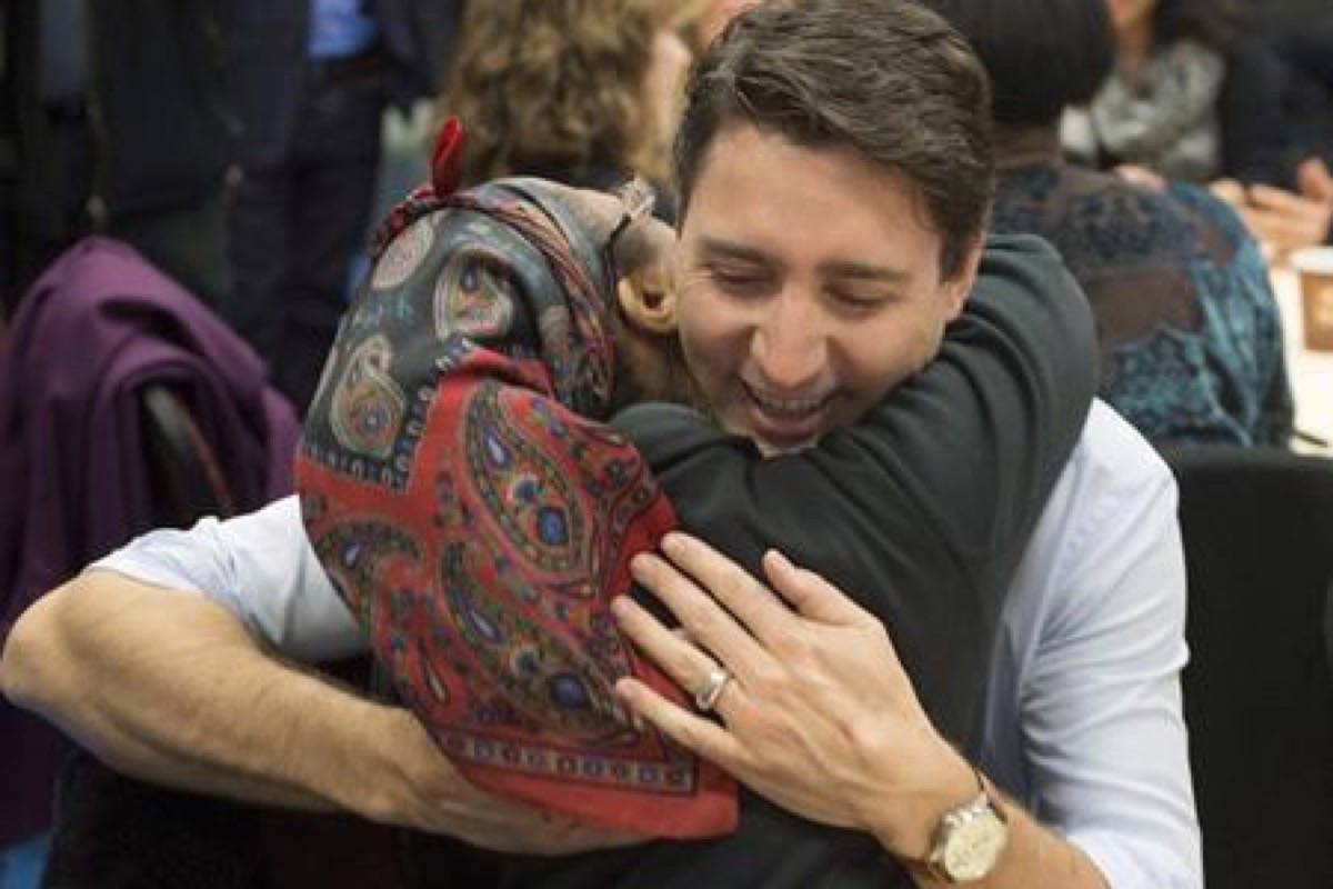 Prime Minister Justin Trudeau gets a hug as he visits caregivers and their family members at Malvern Family Resource Centre in Toronto on March 31, 2017. (Frank Gunn/The Canadian Press)
