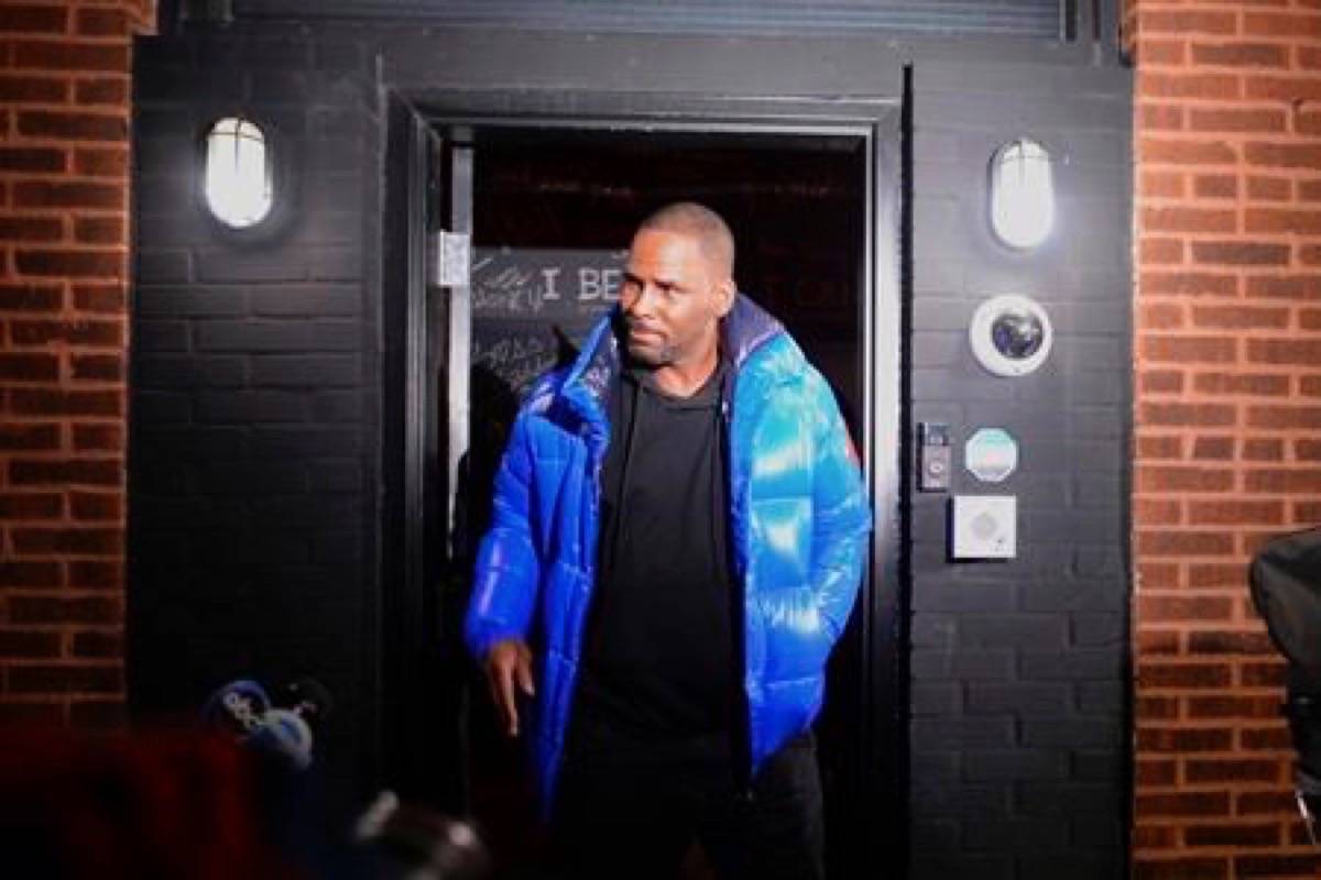 Musician R. Kelly leaves his Chicago studio on his way to surrender to police Friday night, Feb. 22, 2019. R&B star Kelly arrived Friday night at a Chicago police precinct, hours after authorities announced multiple charges of aggravated sexual abuse involving four victims, including at least three between the ages of 13 and 17. (Victor Hilitski/Chicago Sun-Times via AP)