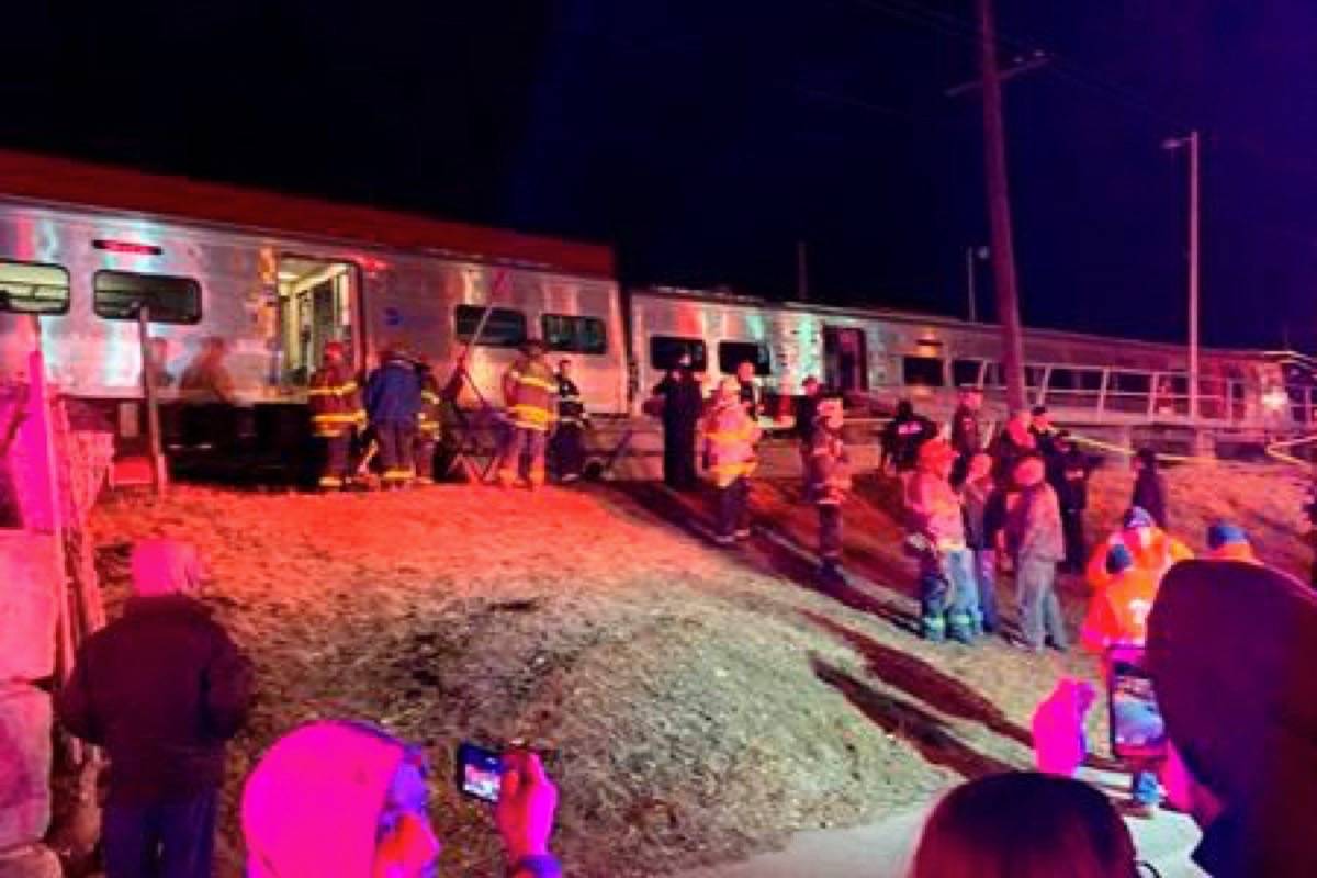 First responders work the scene of a collision involving a Manhattan-bound commuter train and a vehicle in Westbury, N.Y., Tuesday, Feb. 26, 2019. The Long Island Railroad says service was suspended Tuesday evening in both directions on the Ronkonkoma and Huntington/Port Jefferson branches. (Howard Schnapp/Newsday via AP)