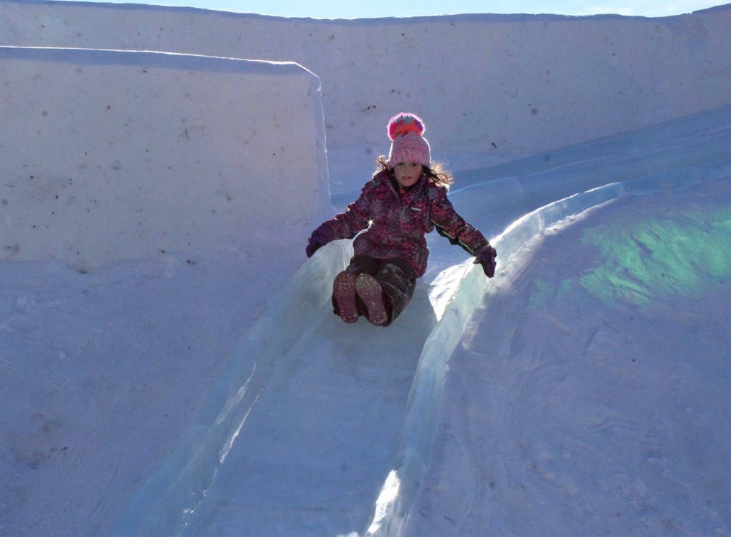 Kourtney Veldman, six, of Sylvan Lake, takes a ride down the ice slide near the Gary W. Harris Celebration Plaza. Carlie Connolly/Red Deer Express