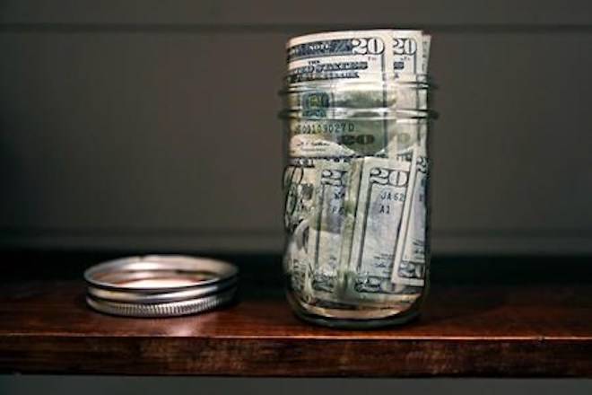 FILE - In this June 15, 2018, file photo a canning jar filled with currency sits on a shelf in East Derry, N.H. (AP Photo/Charles Krupa, File)
