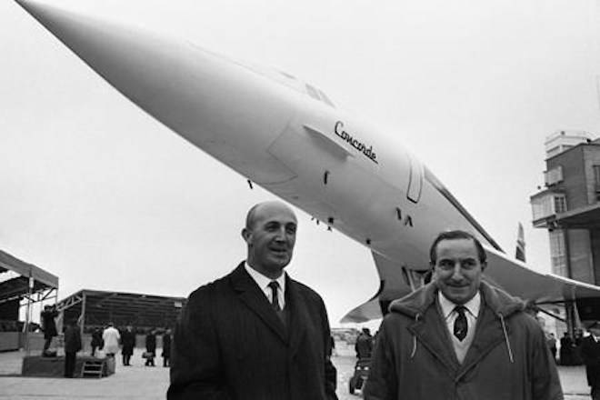 FILE - In this Dec. 11, 1967, file photo, two test pilots who will fly the Concorde, the British-French supersonic airliner, Andre Turcat, of France and left, British pilot Brian Trubshaw, stand in front of the prototype of the jet during its roll out ceremony in Toulouse, France. (AP Photo/Peter Kemp, File)