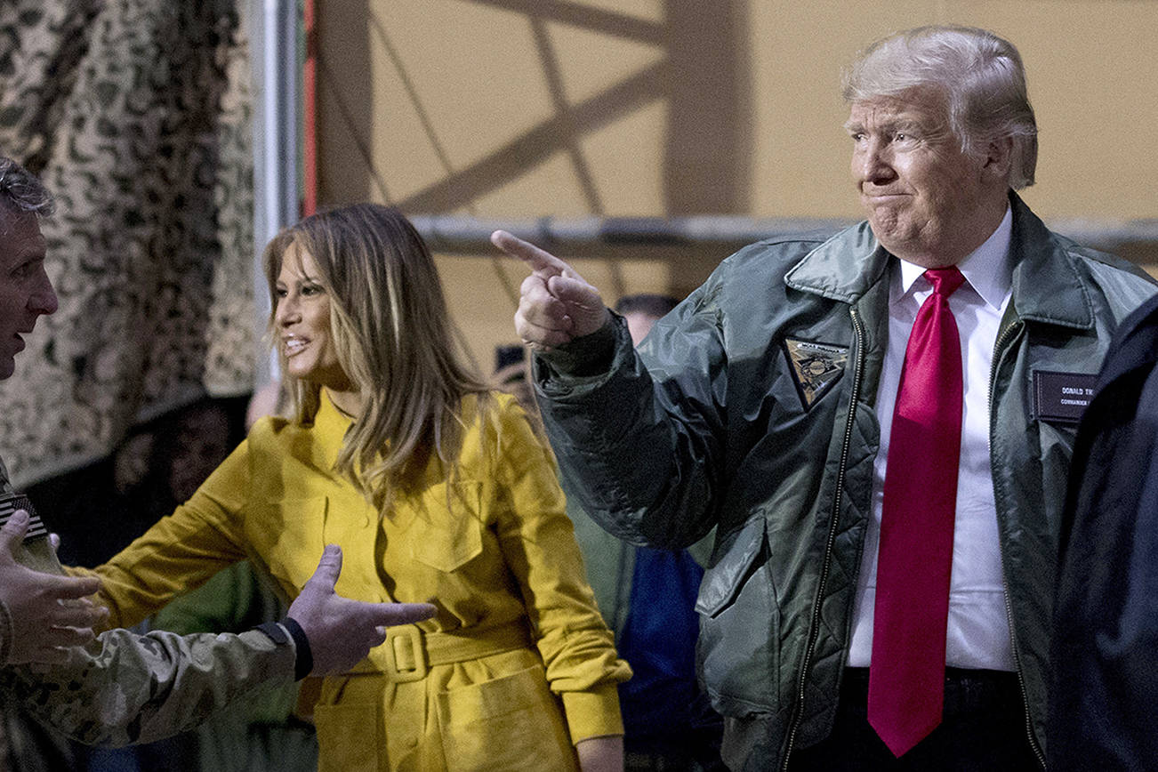 President Donald Trump and first lady Melania Trump greet members of the military as they arrive for a hanger rally at Al Asad Air Base, Iraq, Wednesday, Dec. 26, 2018. In a surprise trip to Iraq, President Donald Trump on Wednesday defended his decision to withdraw U.S. forces from Syria where they have been helping battle Islamic State militants. (AP Photo/Andrew Harnik)