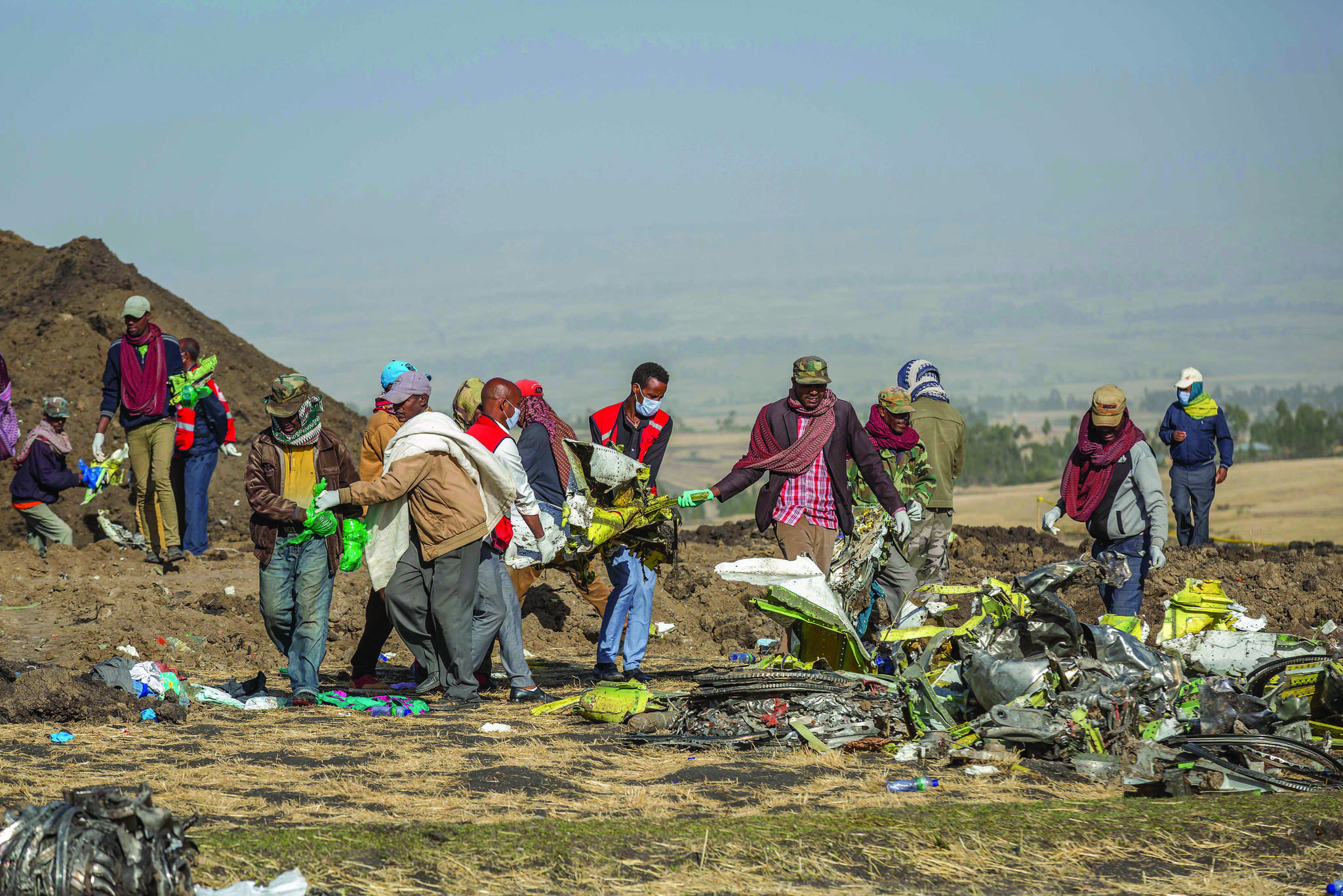 Rescuers work at the scene of an Ethiopian Airlines flight crash near Bishoftu, or Debre Zeit, south of Addis Ababa, Ethiopia, Monday, March 11, 2019. A spokesman says Ethiopian Airlines has grounded all its Boeing 737 Max 8 aircraft as a safety precaution, following the crash of one of its planes in which 157 people were killed. (AP Photo/Mulugeta Ayene)