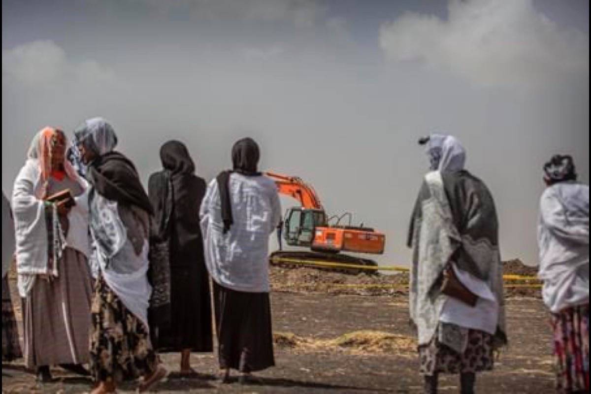 Ethiopian relatives of crash victims mourn as a mechanical digger operates at the scene where the Ethiopian Airlines Boeing 737 Max 8 crashed shortly after takeoff on Sunday killing all 157 on board, near Bishoftu, south-east of Addis Ababa, in Ethiopia Thursday, March 14, 2019. (AP Photo/Mulugeta Ayene)