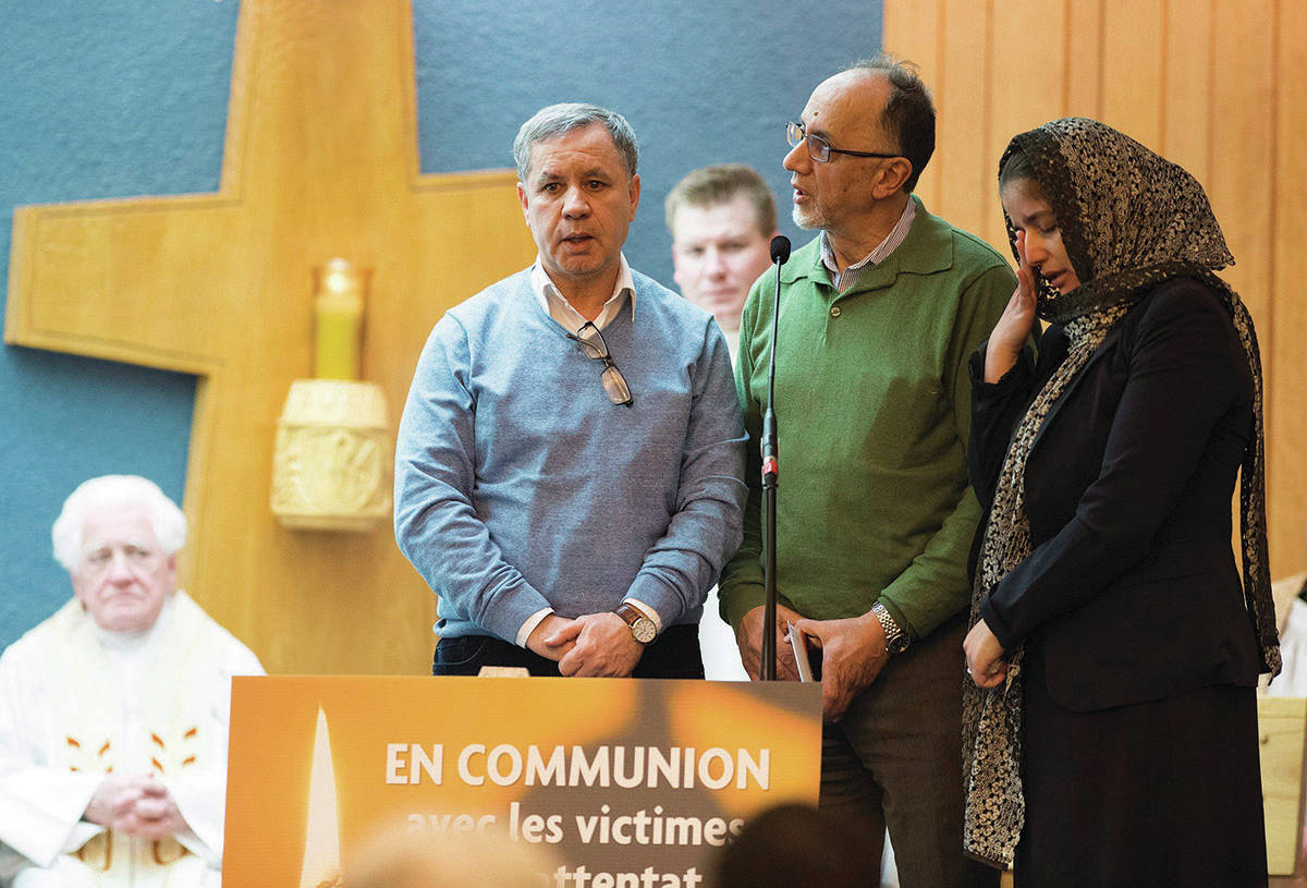 Boufeldja Benabdallah, centre, co-founder of the Quebec Islamic Centre, flanked by two members of the muslim community, recite a verse from the Qur’ an, at a catholic mass in communion with the victims of the mosque shooting, Tuesday, January 31, 2017 in Quebec City. (Jacques Boissinot/The Canadian Press)