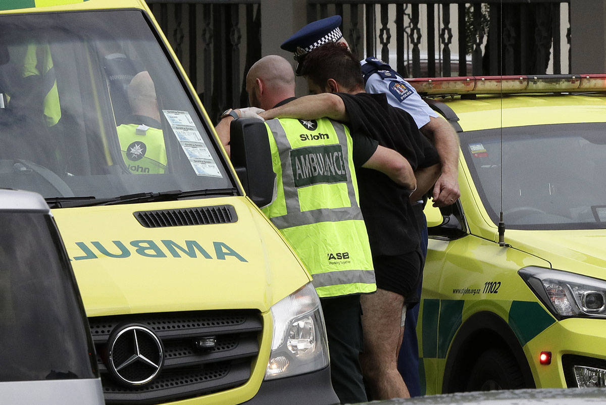Police and ambulance staff help a wounded man from outside a mosque in central Christchurch, New Zealand, Friday, March 15, 2019. A witness says many people have been killed in a mass shooting at a mosque in the New Zealand city of Christchurch. (AP Photo/Mark Baker)