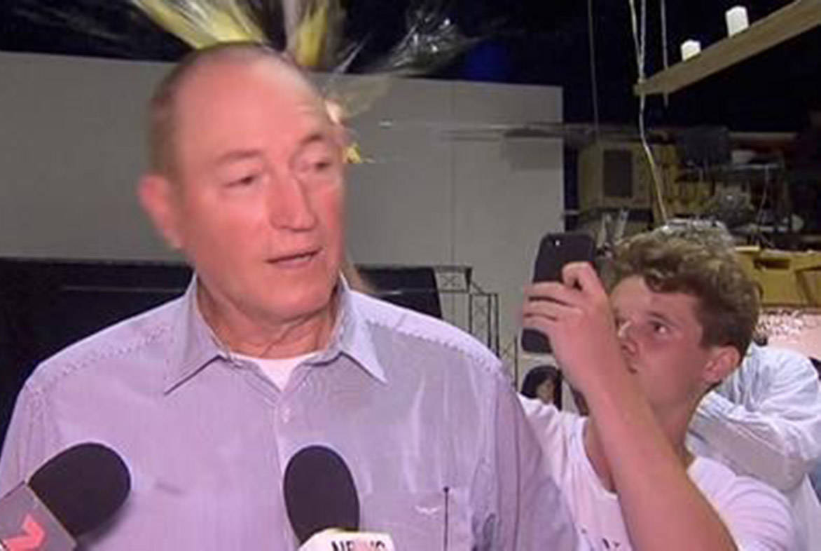 In this image made from video, a teenager breaks an egg on the head of Senator Fraser Anning while he holds a press conference, Saturday, March 16, 2019, in Melbourne, New Zealand. Following the mass shootings on Friday, Anning came under sharp criticism over tweets including one that said: “Does anyone still dispute the link between Muslim immigration and violence?” (AP Photo)