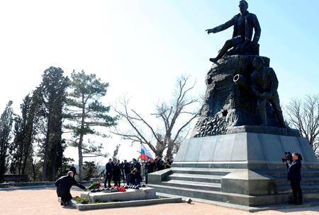 Russian President Vladimir Putin, left, puts a bunch of flowers to the monument to Vice-Admiral Vladimir Kornilov at the historical memorial the Malakhov Kurgan (Malakoff redoubt) in Sevastopol, Crimea, Monday, March 18, 2019. (Mikhail Klimentyev, Sputnik, Kremlin Pool Photo via AP)