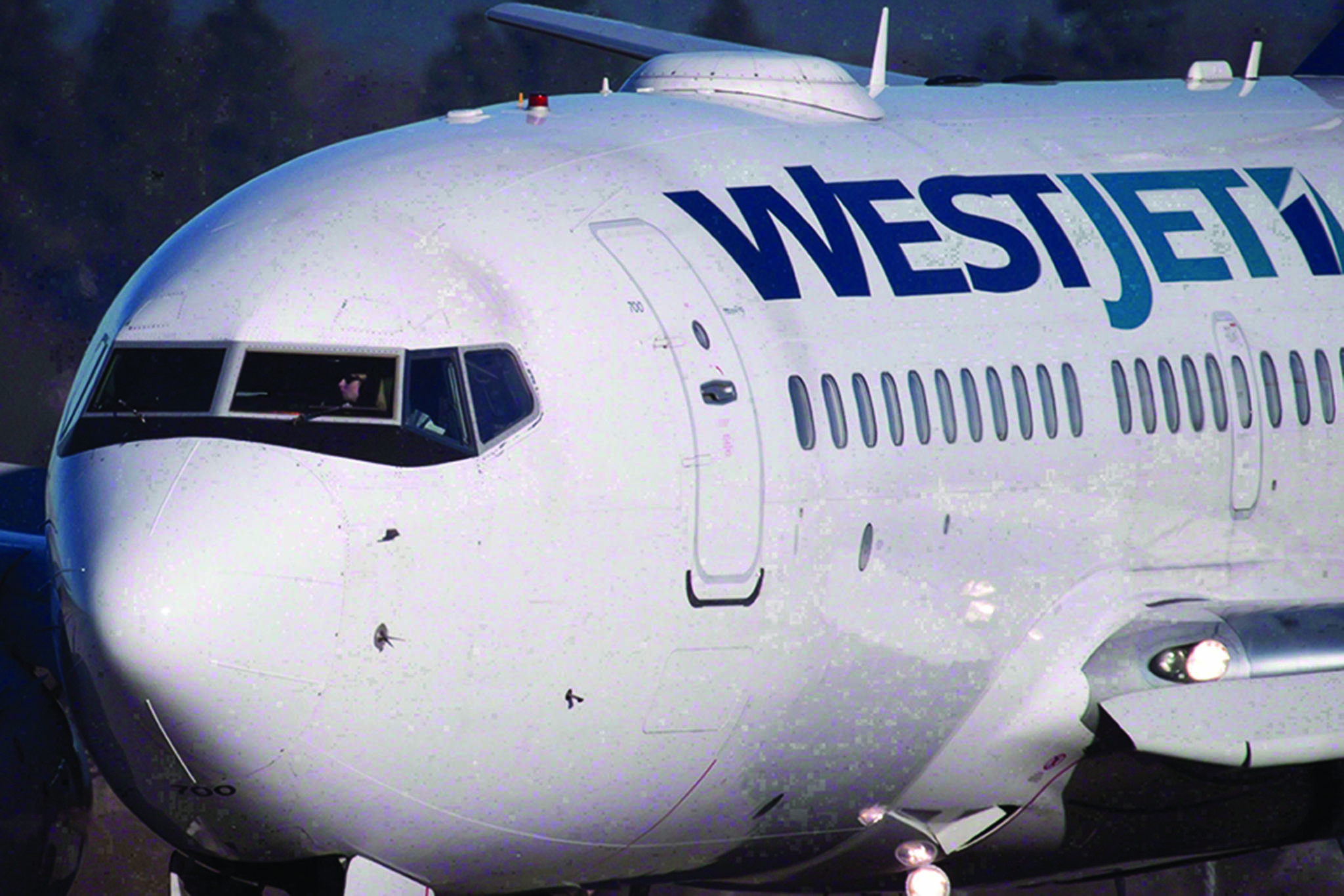 A pilot taxis a Westjet Boeing 737-700 plane to a gate after arriving at Vancouver International Airport on February 3, 2014. The union that represents pilots at WestJet has called for a strike vote to press its demand for a contract. THE CANADIAN PRESS/Darryl Dyck