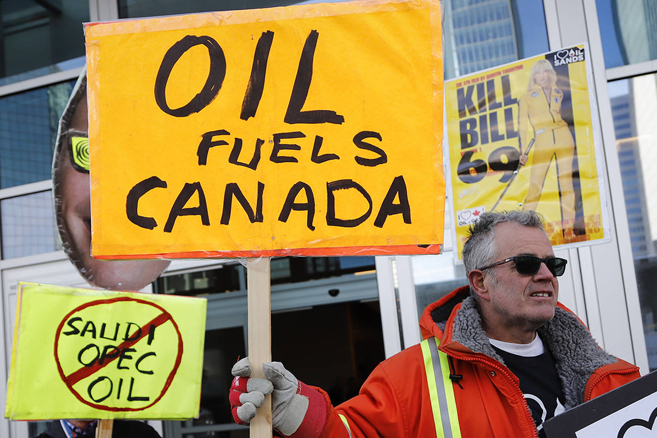 Oil and gas supporters picket outside the National Energy Board, during the release of the board’s reconsideration report on marine shipping related to the Trans Mountain expansion project, in Calgary, Alberta, Canada, Friday, Feb. 22, 2019. (Jeff McIntosh/The Canadian Press via AP)