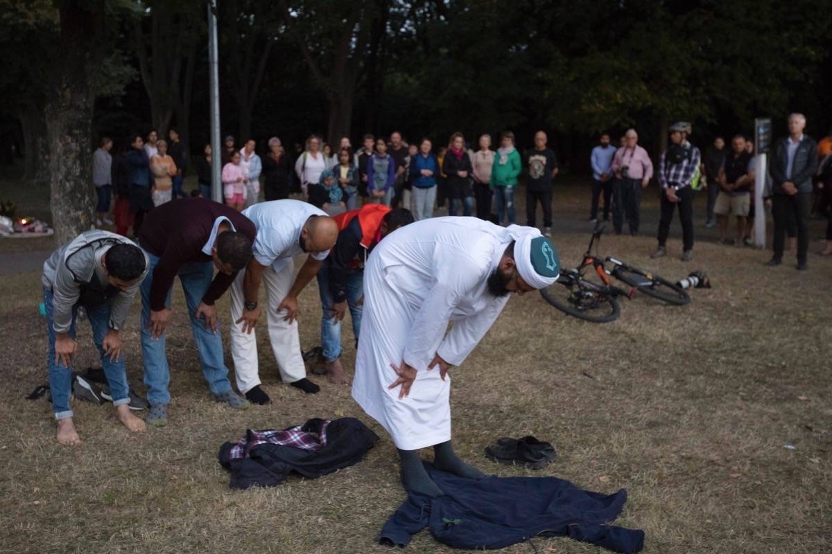 Muslims offer prayer near the main road to the Al Noor mosque in Christchurch, New Zealand, Tuesday, March 19, 2019. Streets near the hospital that had been closed for four days reopened to traffic as relatives and friends of the victims of last week’s mass shootings continued to stream in from around the world. (AP Photo/Vincent Thian)