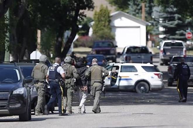 The RCMP emergency response unit arrests an alleged suspect in Neepawa, Man., on Thursday, August 30, 2018, following the shooting of a RCMP officer in Onanole, Man. THE CANADIAN PRESS/John Woods