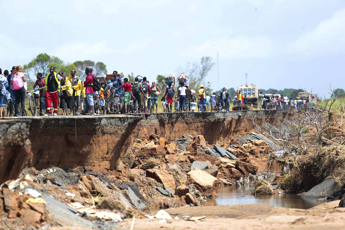 People pass through a section of the road damaged by Cyclone Idai in Nhamatanda about 50 kilometres from Beira, in Mozambique, Friday March, 22, 2019. As flood waters began to recede in parts of Mozambique on Friday, fears rose that the death toll could soar as bodies are revealed. (Tsvangirayi Mukwazhi/AP)