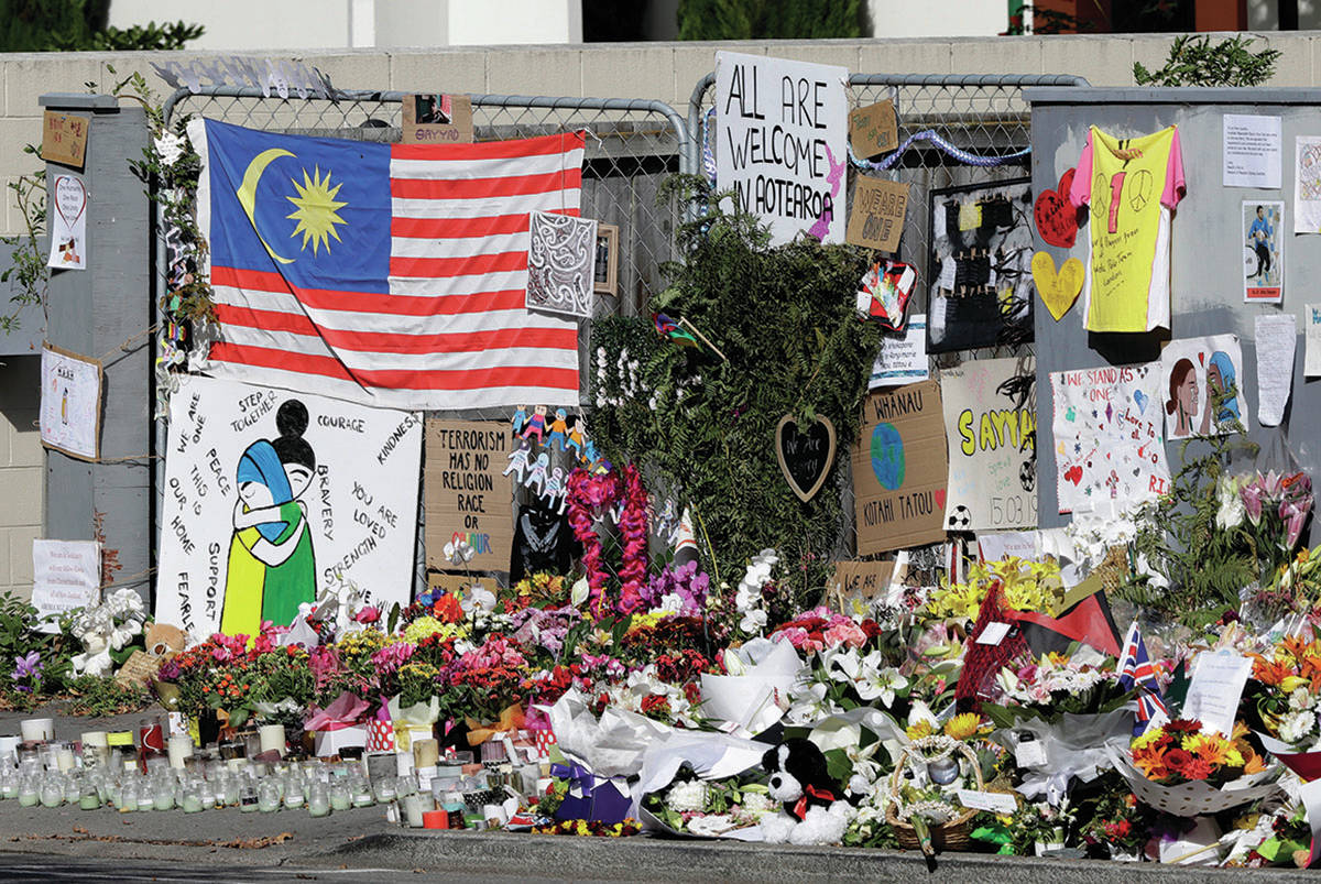 Tributes hang on the fence outside the Al Noor mosque in Christchurch, New Zealand, Friday, March 22, 2019. In a day without precedent in New Zealand, people across the country were planning to observe the Muslim call to prayer as the nation reflected on the moment one week ago when 50 people were slaughtered at two mosques. (AP Photo/Mark Baker)