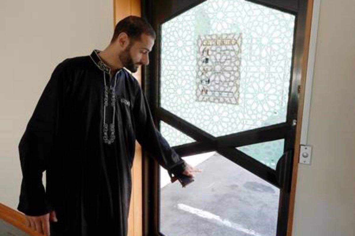In this March 27, 2019, photo, Al Noor mosque volunteer Khaled Alnobani gestures as he explains his escape through a glass door panel when a gunman burst into the mosque on March 15 in Christchurch, New Zealand. Alnobani says he thinks as many as 17 people may have died trying to get out through the door. (AP Photo/Mark Baker)