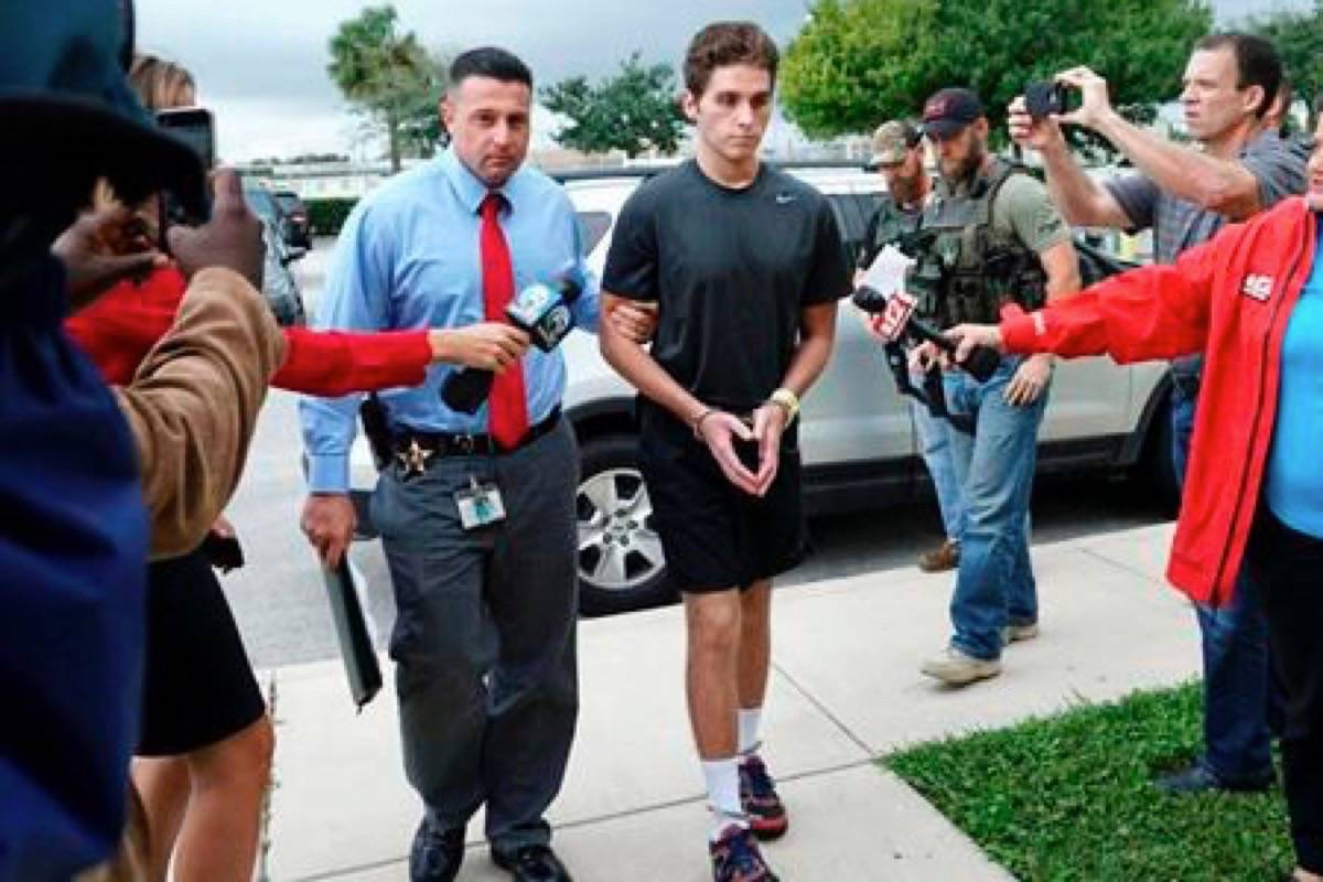 FILE - In this Oct. 3, 2016 file photo, Austin Harrouff is transported by detectives to the Martin County Jail from St. Mary’s Hospital in Stuart, Fla. A forensic psychologist says Harrouff, a former college student believed he was “half-dog, half-man” when he fatally attacked a man and woman at their home and was found biting one of their faces. Dr. Phillip Resnick made the conclusion in a 38-page mental-health report released this week of March 29, 2019, by the Martin County State Attorney’s Office. (Richard Graulich/Palm Beach Post via AP)