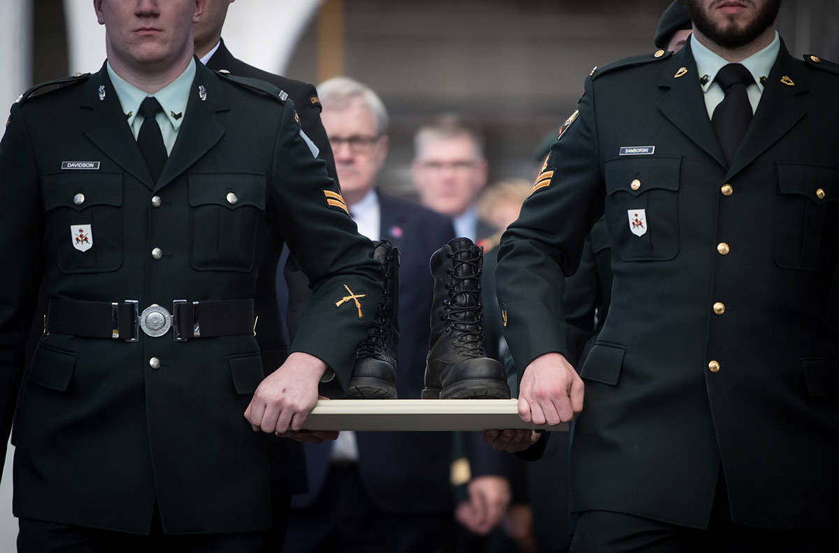 Members of the Canadian Forces carry a pair of combat boots to a VIA Rail train to begin their journey to Halifax, at Pacific Central Station in Vancouver, on Friday March 29, 2019. The boots will travel across the country on the train to symbolize those who travelled to Halifax during the Second World War before they embarked for Europe. The journey is part of the federal government’s plan to commemorate the 7th anniversary of D-Day and the Battle of Normandy. (Darryl Dyck/The Canadian Press)